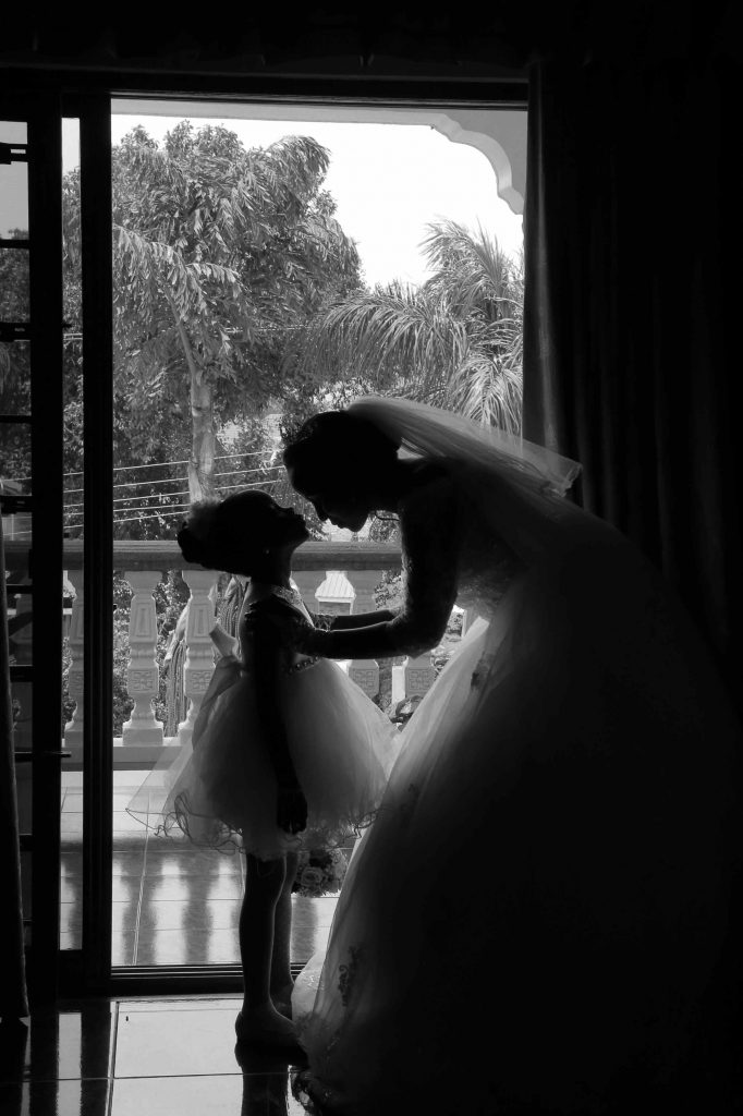 
Black and white portrait of the bride Whispering to the Flower girl